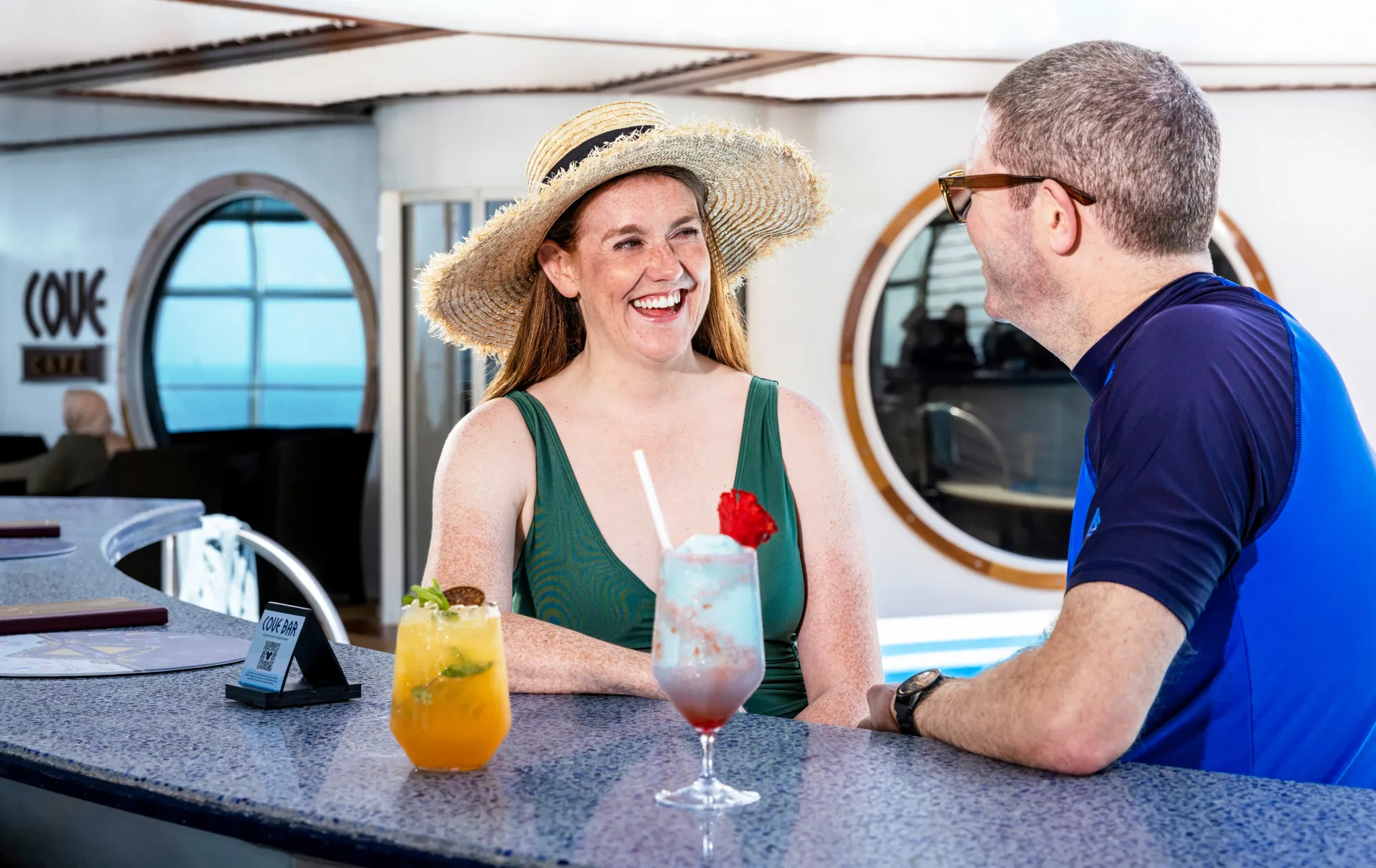 A man and a woman having cocktails on a Disney Cruise Line ship