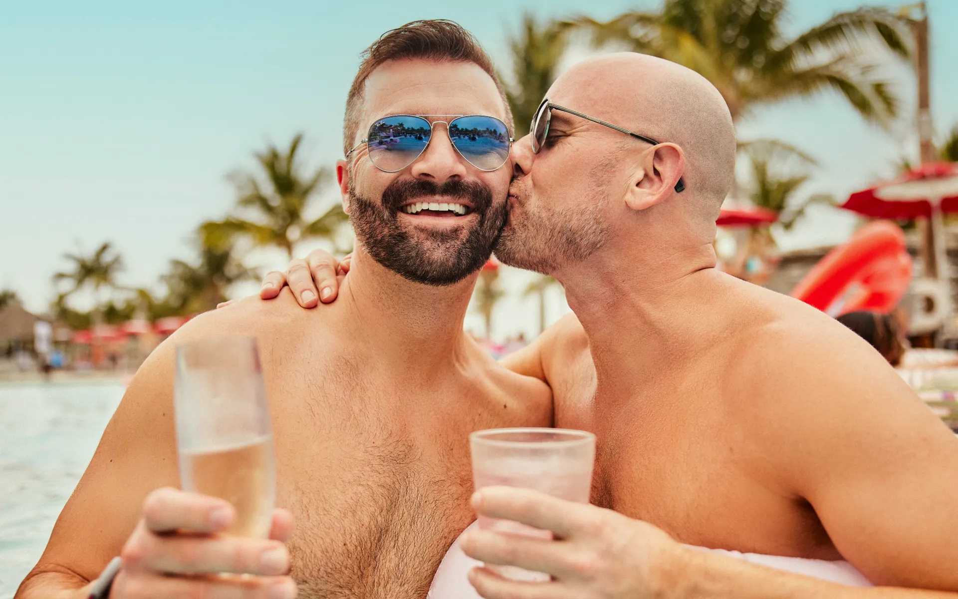 A couple enjoying drinks in a pool on holiday