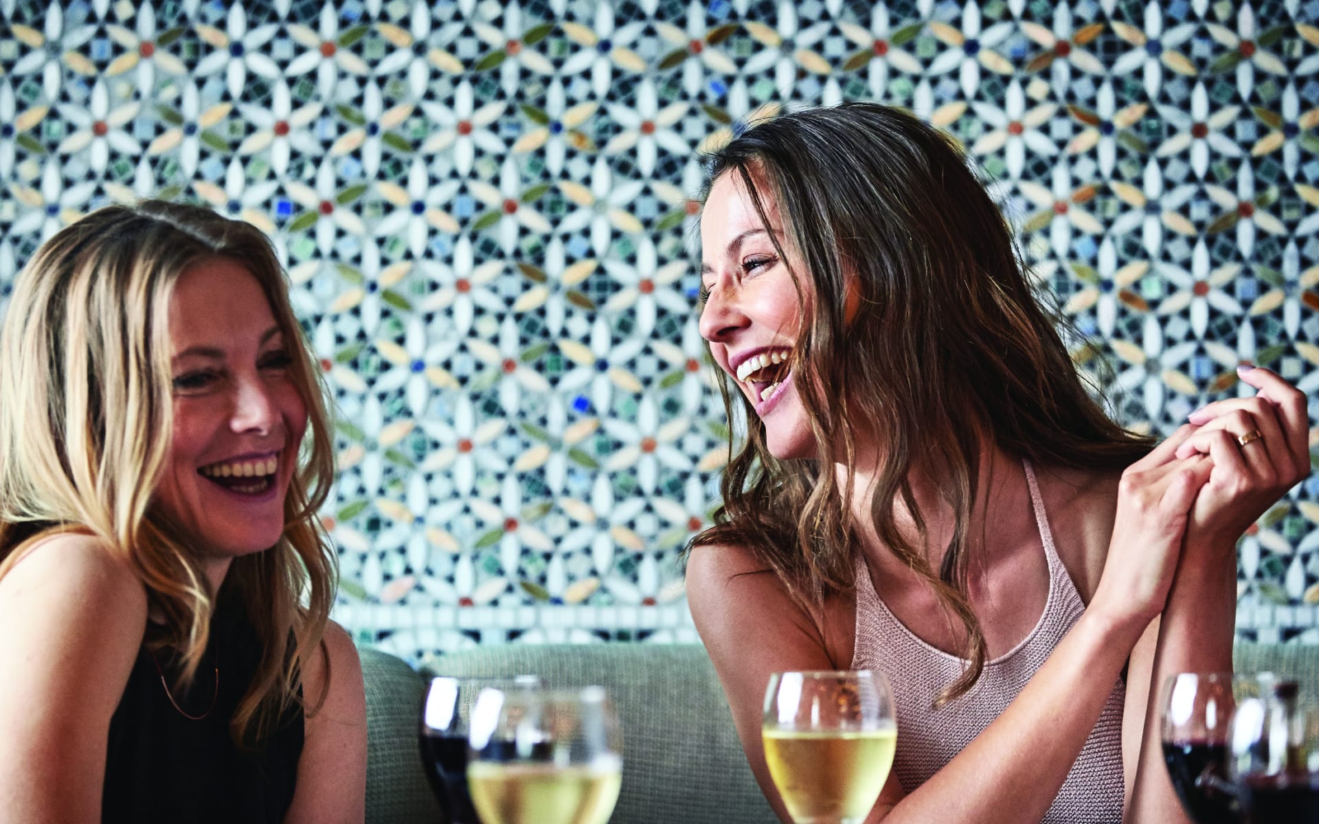 An image of two women laughing in a restaurant