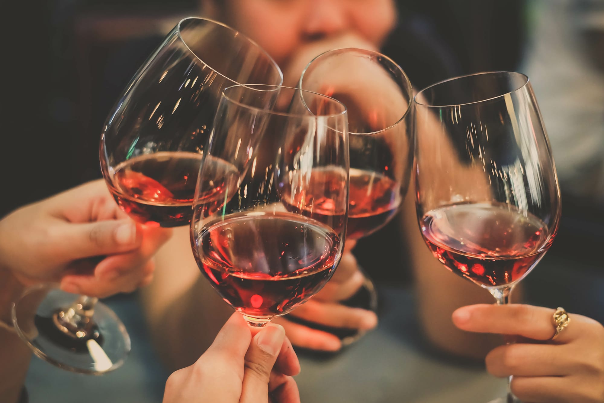 People celebrating by cheering with wine glasses
