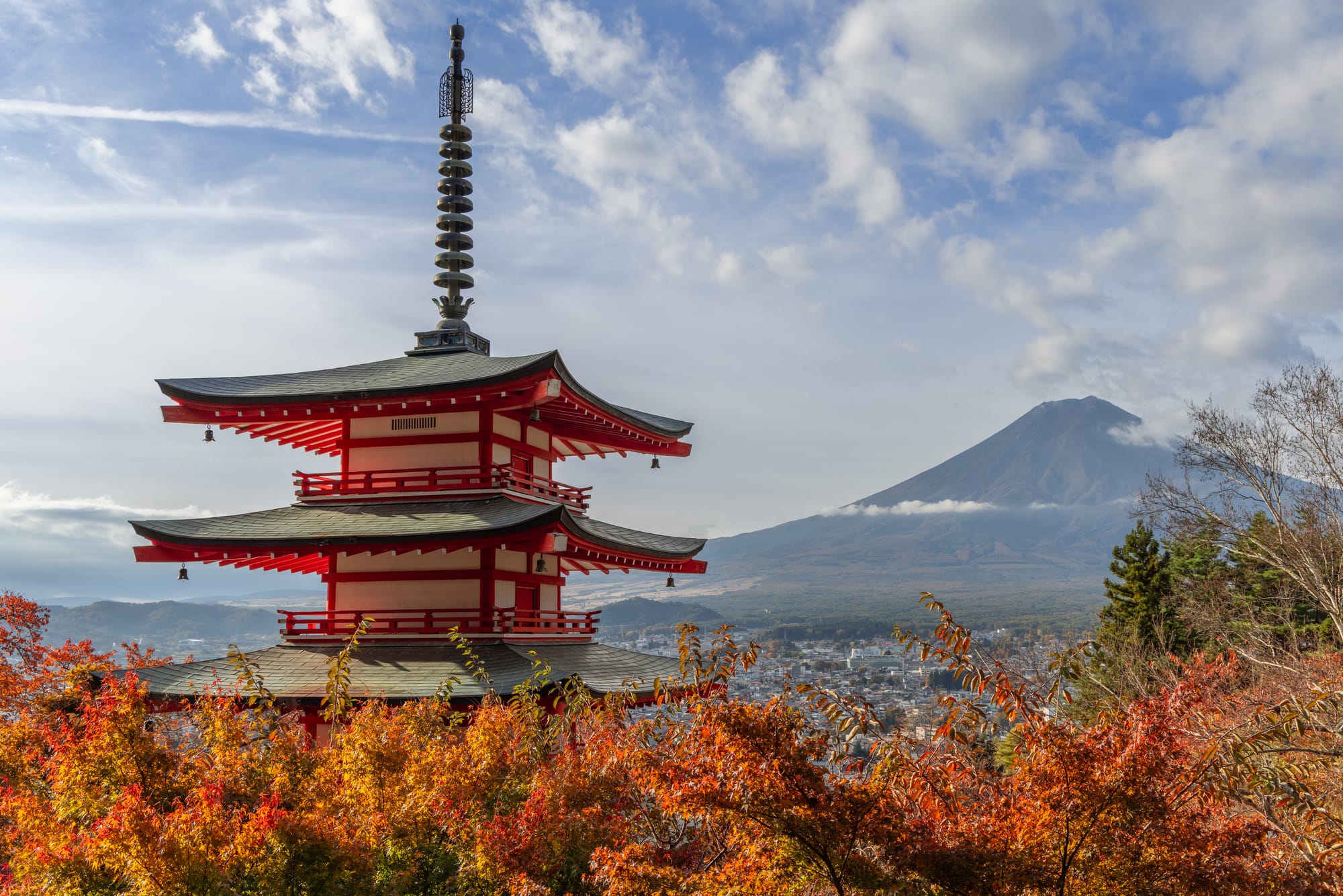 An image of a traditional Japanese pagoda with Mount Fuji in the background, far away