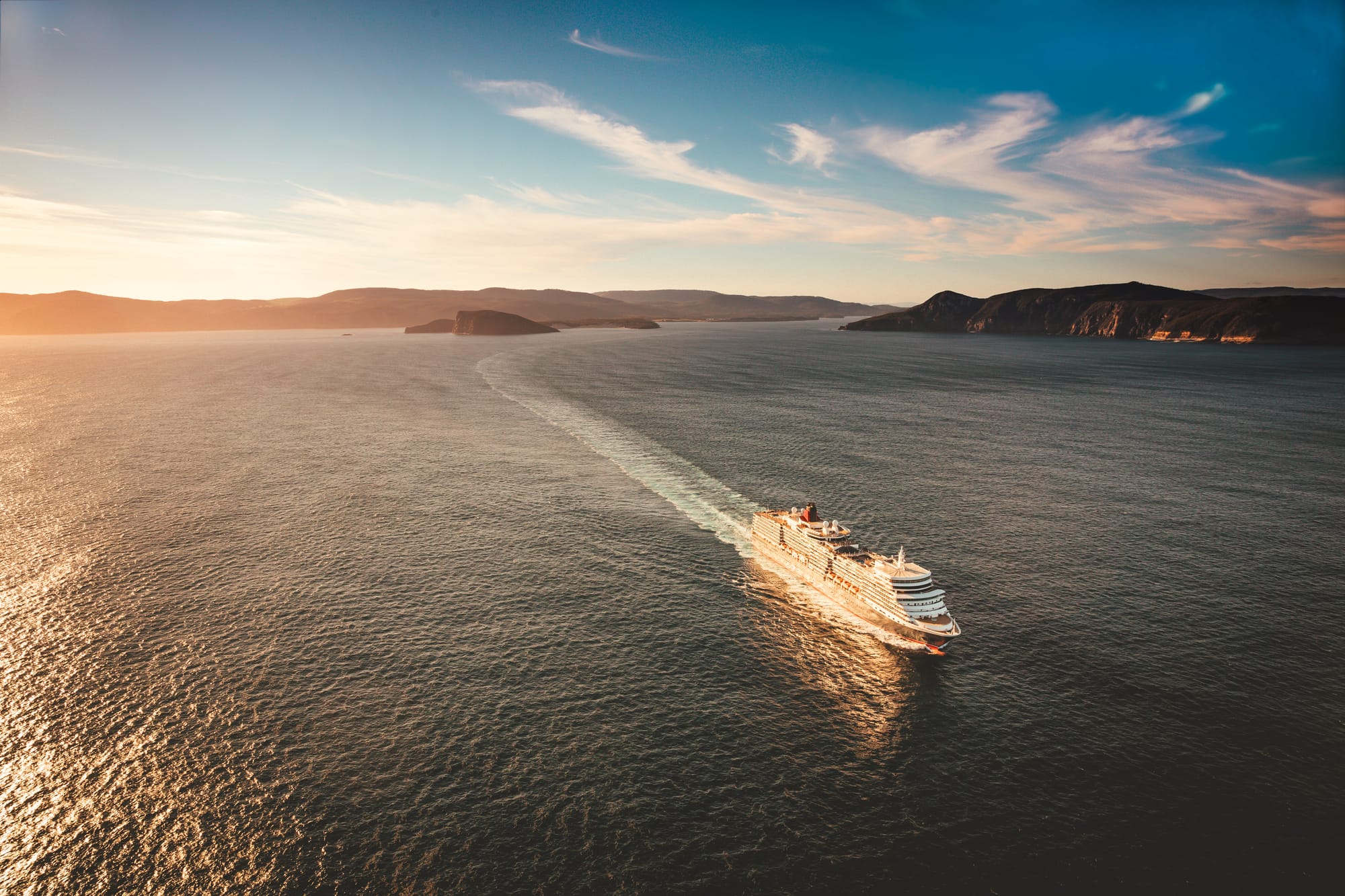 An image of a cruise ship sailing at dusk in open waters around Tasmania